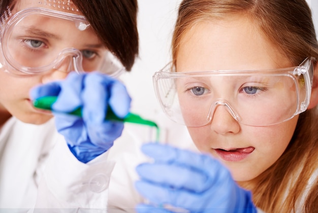 Foto grátis cooperação de pequenos cientistas em laboratório