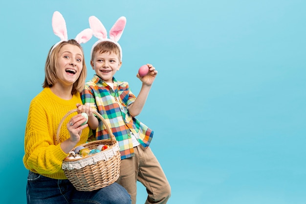 Cópia-espaço mãe e filho mostrando ovos pintados