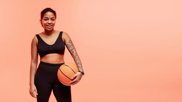 Foto grátis cópia-espaço mulher com bola de basquete