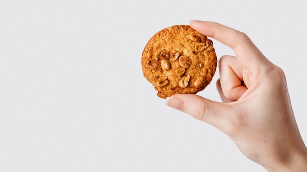 copie a mão do espaço com biscoito