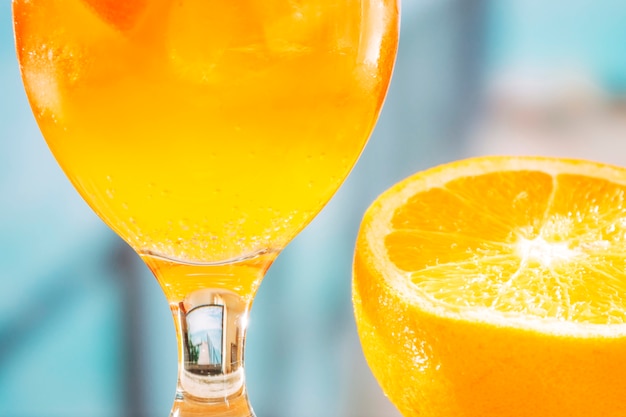 Copo com bebida de laranja e laranja fatiada