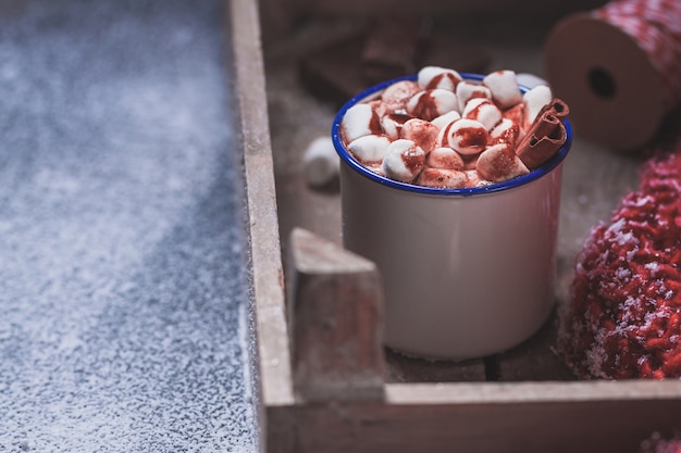 Copo com marshmallows em uma bandeja de madeira