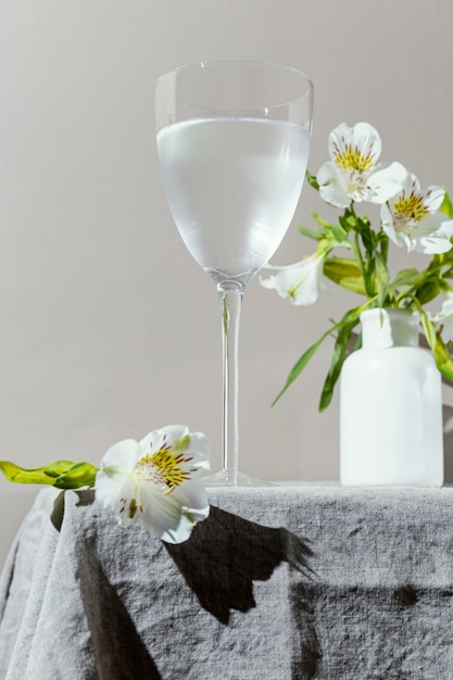 Copo de água e flores na mesa
