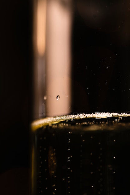 Foto grátis copo de baixo ângulo com champanhe no fundo