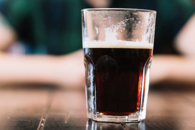 Copo de bebida alcoólica na mesa de madeira