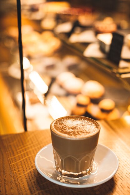 Copo de café com leite delicioso com fundo de item de padaria de desfocagem