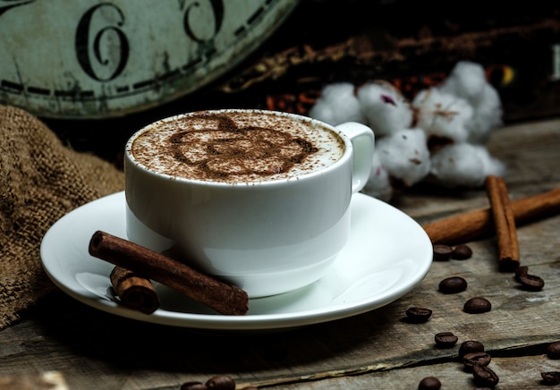 Copo de cappuccino quente com padrão de canela