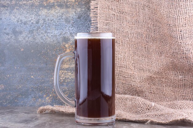 Copo de cerveja escura na mesa de mármore. Foto de alta qualidade