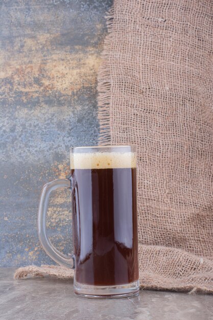 Foto grátis copo de cerveja escura na mesa de mármore. foto de alta qualidade