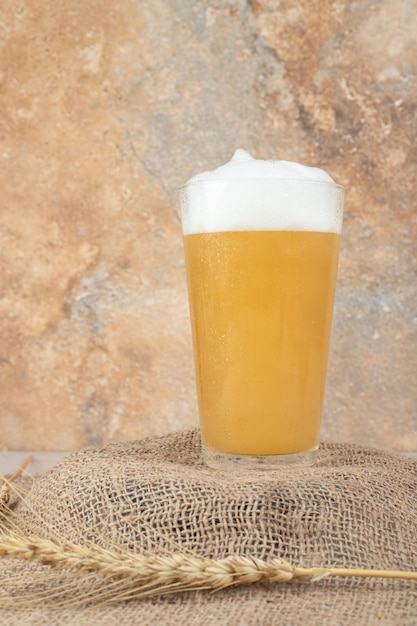 Foto grátis copo de cerveja espumosa no trigo de serapilheira