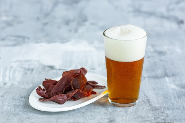 Copo de cerveja na mesa de pedra e superfície de tijolos