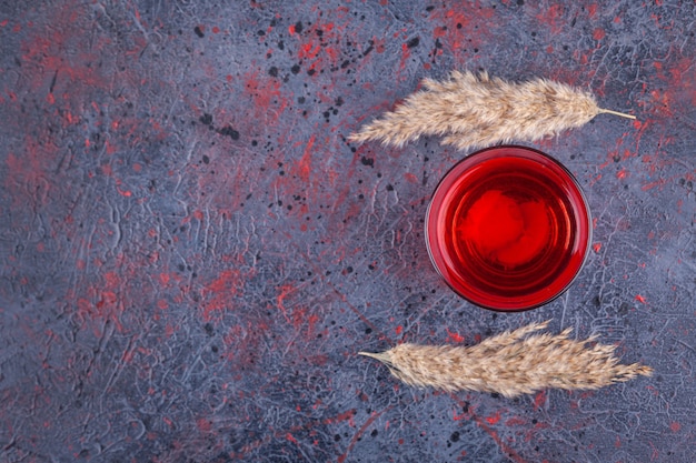 Foto grátis copo de coquetel vermelho com fatias de frutas em mármore.