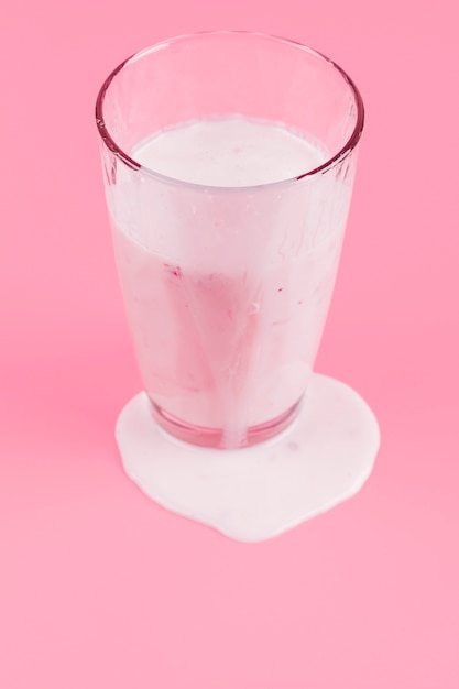 Copo de iogurte em fundo rosa