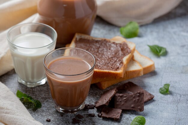 Copo de leite com chocolate na superfície escura.
