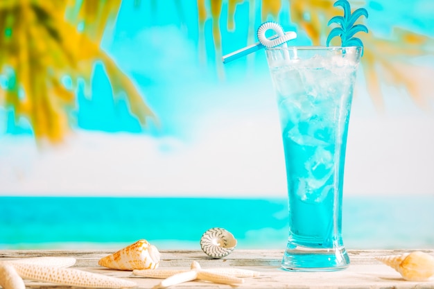 Foto grátis copo de refrigerante bebida azul e estrelas do mar