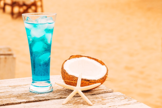 Copo de refrigerante bebida azul e mesa de madeira de coco rachado