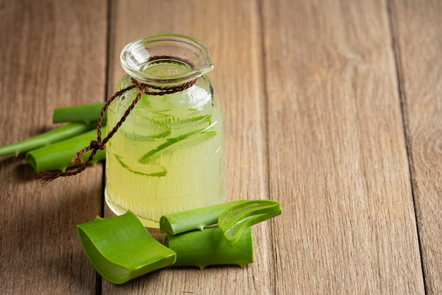 Copo de suco de aloe vera colocado no chão de madeira