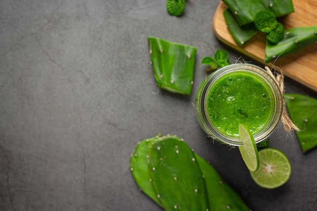 copo de suco de aloe vera colocado no chão escuro