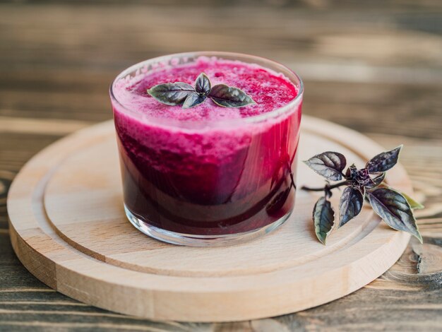 Copo de suco de beterraba na bandeja de madeira