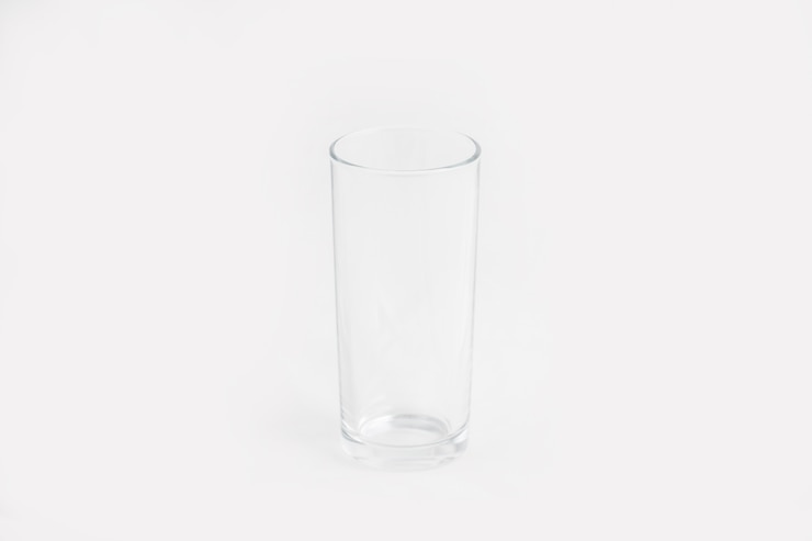 Foto grátis copo de vidro transparente elegante isolado em uma parede branca