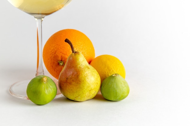 Copo de vinho branco com frutas frescas em uma mesa branca leve beber álcool barra de frutas de água