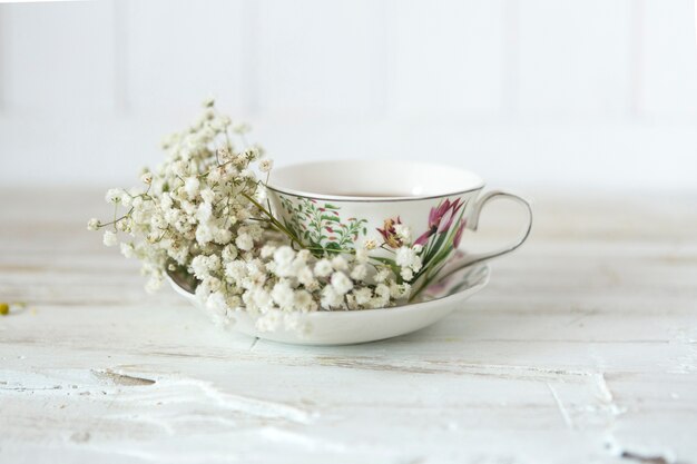Copo do chá com flores decorativas