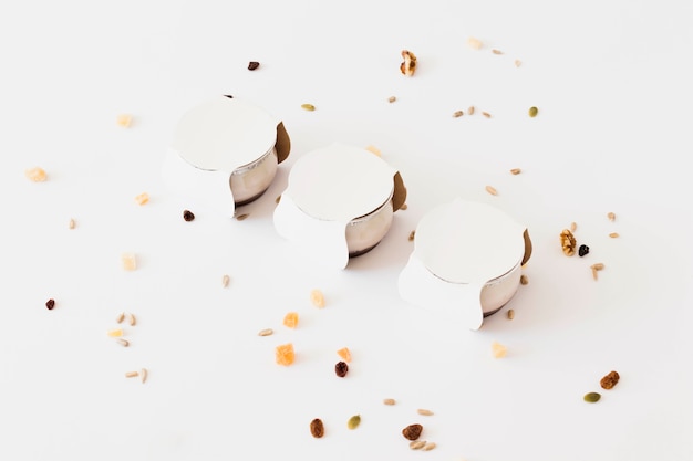Foto grátis copos brancos para iogurte entre frutas secas