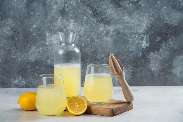 Copos cheios de limonada com rodela de limão e escareador de madeira.