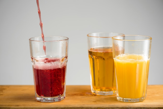 Copos com suco de maçã, laranja e cereja