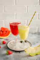 Foto grátis copos com suco de melancia vermelho e amarelo