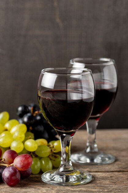 Copos com vinho tinto ao lado de uvas orgânicas