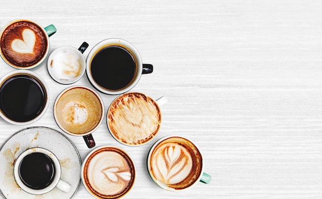 Foto grátis copos de café variados em um plano de fundo texturizado