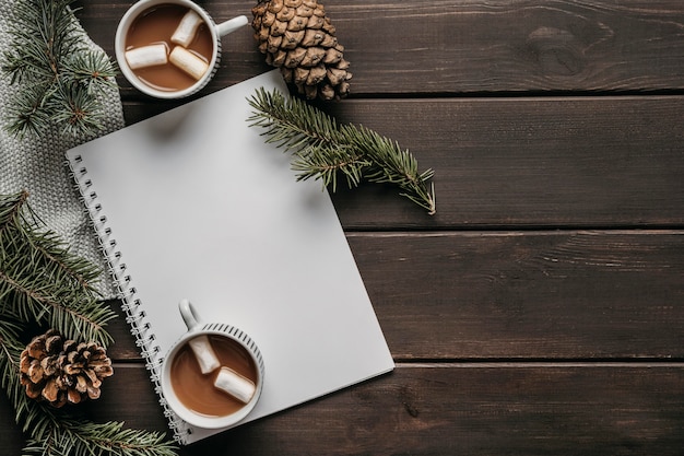 Copos de chocolate quente de vista superior com caderno em branco e cópia-espaço