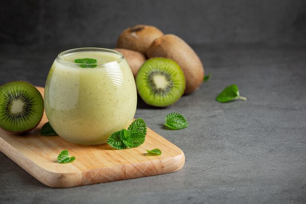 Copos de suco de kiwi colocados em uma tábua de madeira