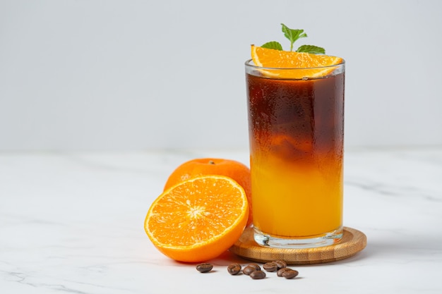 Coquetel de laranja e café na superfície branca.