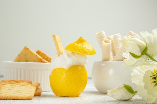 Coquetel de limão com biscoitos na mesa branca de suco de coquetel de frutas cítricas de frente