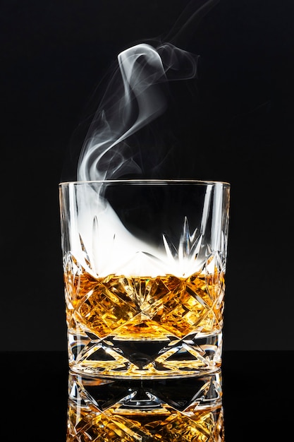Foto grátis coquetel de whisky defumado em fundo preto