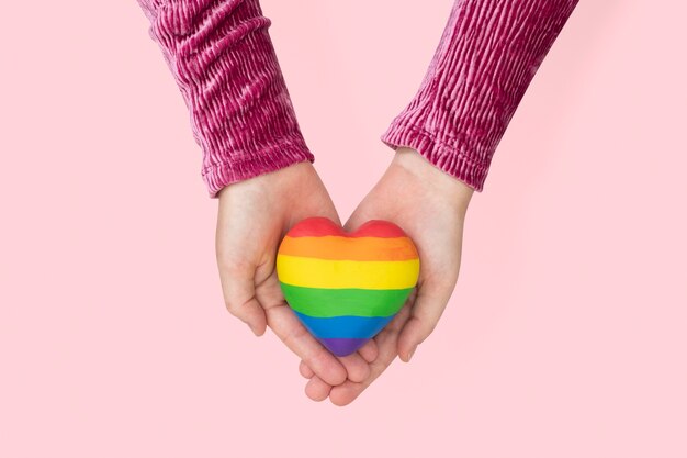 Coração da comunidade LGBTQ + com as mãos apresentando