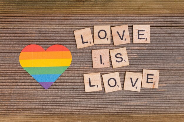 Coração de arco-íris e lema LGBT LOVE is LOVE