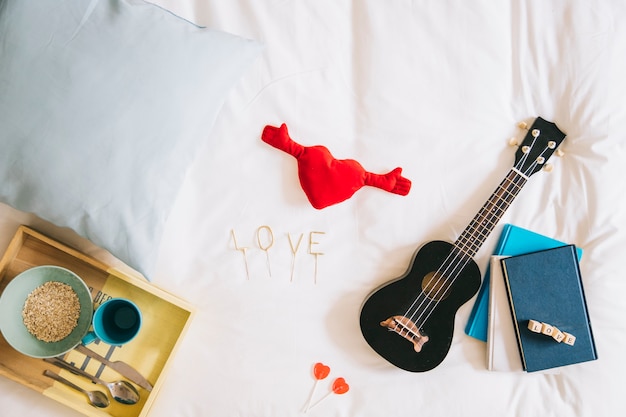 Coração de brinquedo e amor escrevendo perto do ukulele