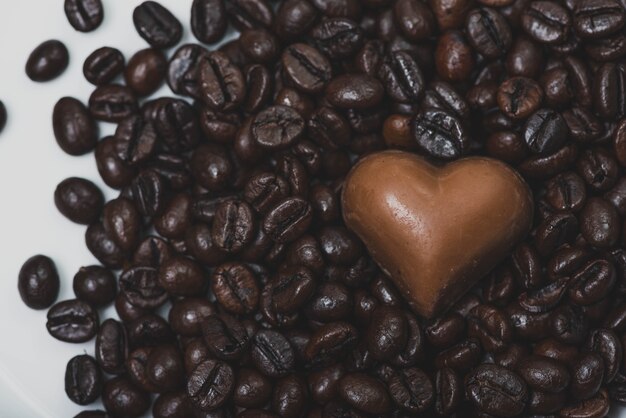Coração de chocolate em feijões de café