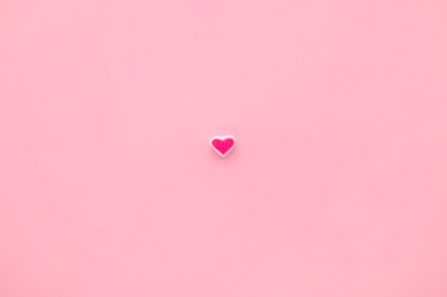 Coração de doce único no fundo rosa