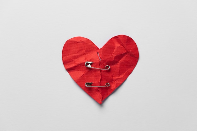 Foto grátis coração vermelho liso leigo com alfinetes de segurança