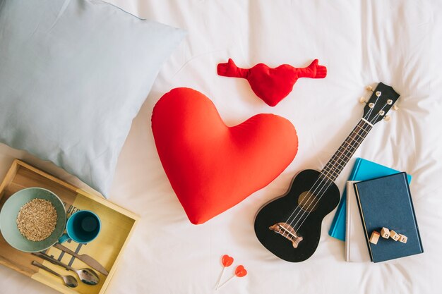 Corações e ukulele bonitos na cama