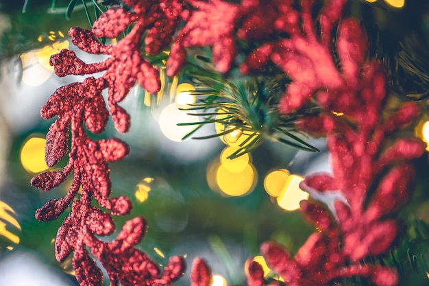 Foto grátis coroa vermelha decorativa em uma árvore de natal com luzes bokeh