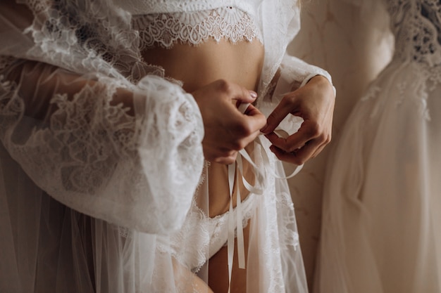 Corpo magro de garota em lingerie branca e lingerie de seda, forma de mulher perfeita