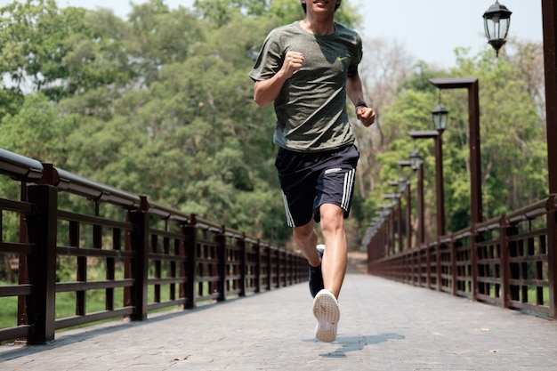 Corredor. conceito exterior de saúde e fitness. o homem joga pela manhã. jovem que faz esportes e jogging em um parque.