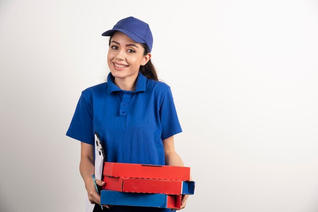 Correio feminino positivo com papelão de pizza e prancheta