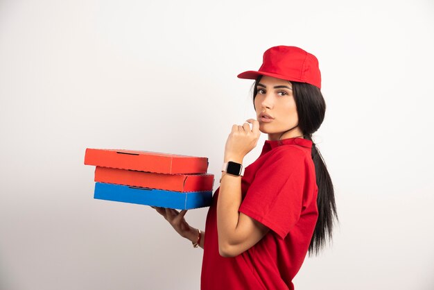 Correio feminino segurando um monte de caixas de pizza.