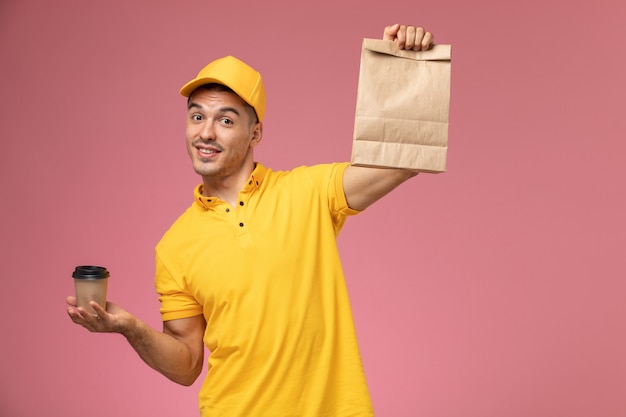 Correio masculino de uniforme amarelo segurando a xícara de café de entrega e o pacote de comida na mesa rosa